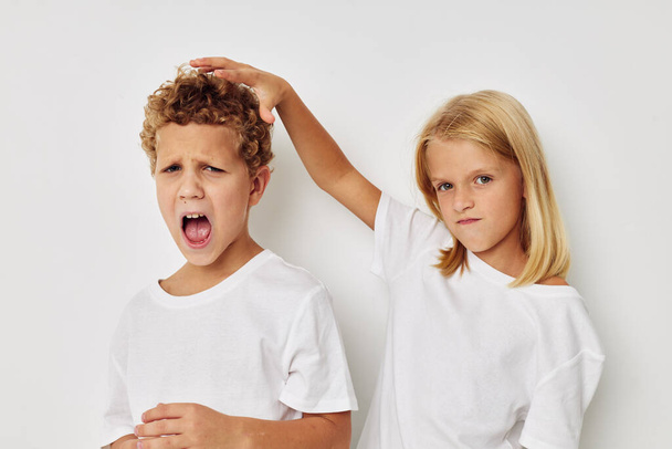 Portrait of cute children in white T-shirts are standing next to childhood unaltered - Foto, Bild