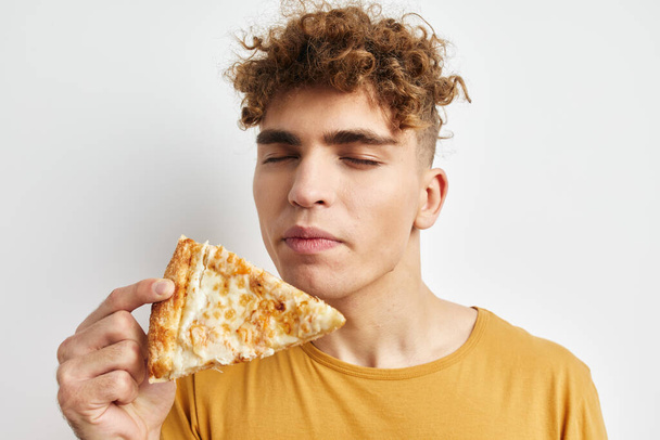 kinky guy eating pizza posing close-up isolated background - Fotó, kép