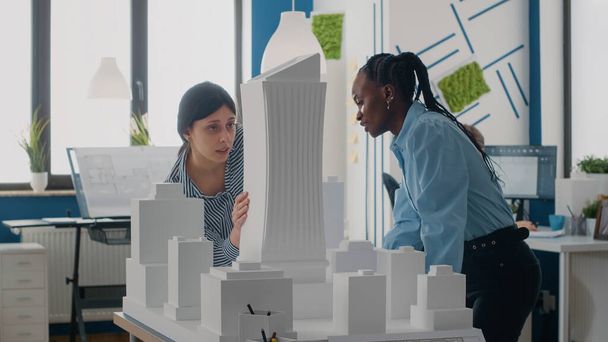 Команда женщин, работающих вместе со строительной моделью для проектирования макета здания - Фото, изображение