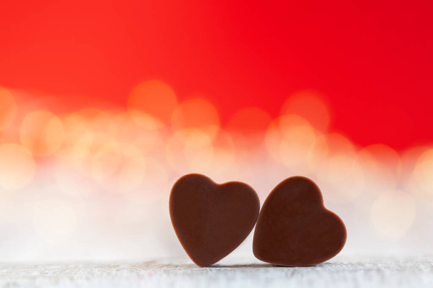 Heart shaped chocolate candies on red background with boke. Happy Valentine's Day greeting card - Foto, Imagem