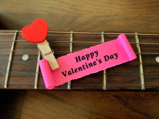 Happy Valentines day label on torn paper with guitar and heart shape background. Valentines Day concept - Zdjęcie, obraz