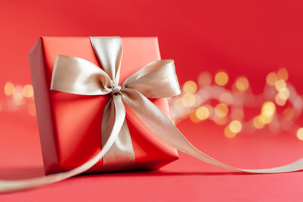 Red gift box or present box with ribbon on red background. Happy Birthday or Valentine's Day concept. - Foto, imagen