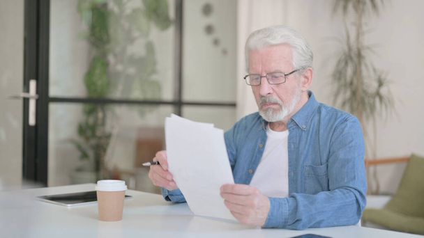 Vieil homme âgé lisant des documents au bureau - Photo, image
