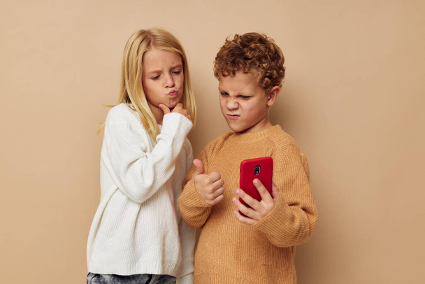 Portrait of cute children hug entertainment selfie posing friendship beige background - Fotó, kép