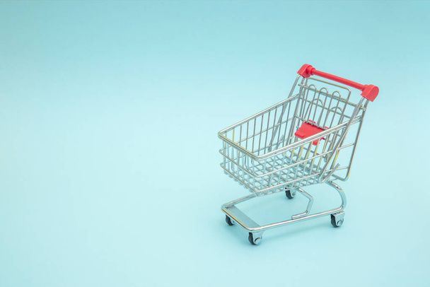 Empty shopping trolley with blue background - Photo, Image