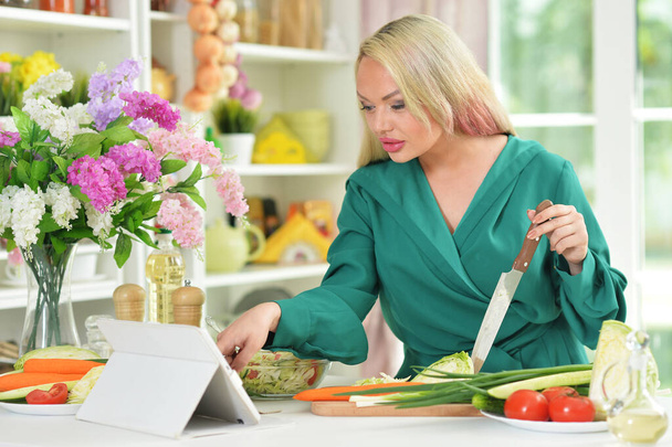 young woman cooking salad in kitchen - Foto, Imagen