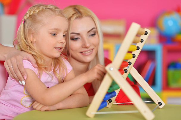 Little girl with mother using abacus - Photo, image