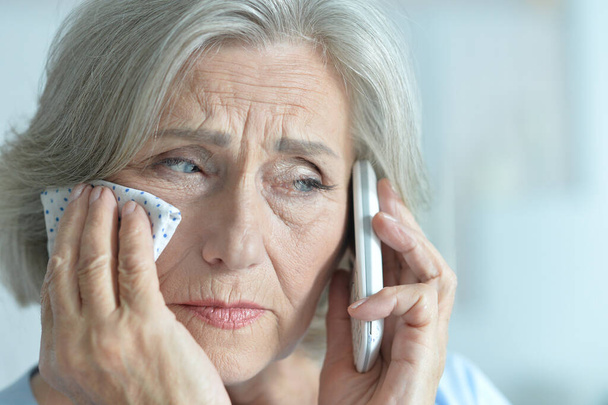 sad senior woman talking on phone - Fotó, kép