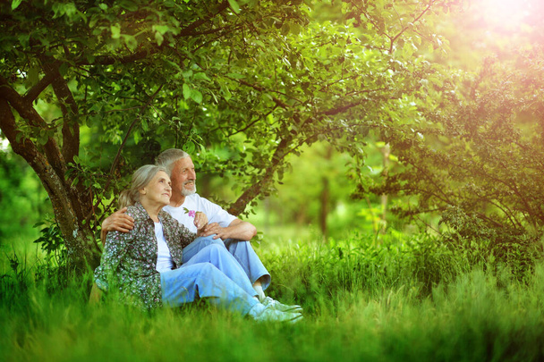 Senior couple sitting on the grass in the park  - Foto, imagen