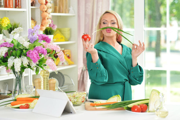young woman cooking salad in kitchen - Foto, Bild