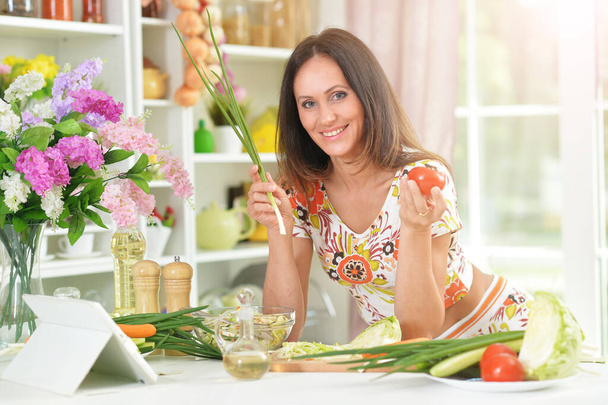 Young woman cooking healthy food in kitchen - Foto, Imagen