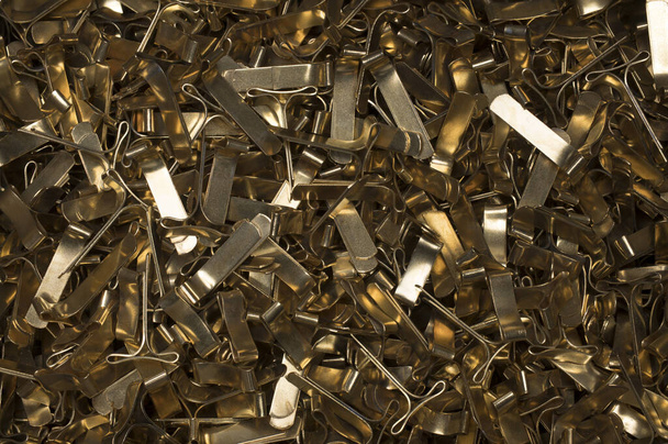 Close up of pile of several brass metal gold staples for sealing cushion envelopes one on top of the other also for use as a background - Photo, Image
