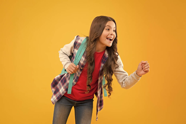 Happy back to school child pretend holding something in hand yellow background, advertising - Zdjęcie, obraz
