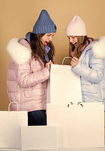 surprised women with package. girls shopping bags. christmas shopping sales. fun and gifts. friendship and sisterhood. black friday. happy new year. xmas presents. winter holidays. family vacation - Foto, Imagen