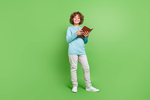 Full length body size view of attractive cheerful guy reading diary library isolated over vivid green color background. - Photo, image