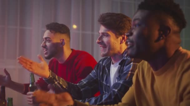 Υποστηρικτές ποδοσφαίρου. Συναισθηματικά νέοι διαφορετικοί άνδρες φίλοι βλέποντας ποδοσφαιρικό αγώνα στην τηλεόραση και ζητωκραυγάζοντας για την αγαπημένη ομάδα - Πλάνα, βίντεο