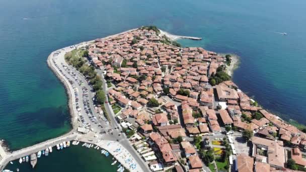 Aerial kuvamateriaalia kauniista rantaviivasta Bulgarian alueella Sunny Beach, Nessebar otettu drone osoittaa pieni pakattu saari taloja, majataloja ja yrityksiä - Materiaali, video