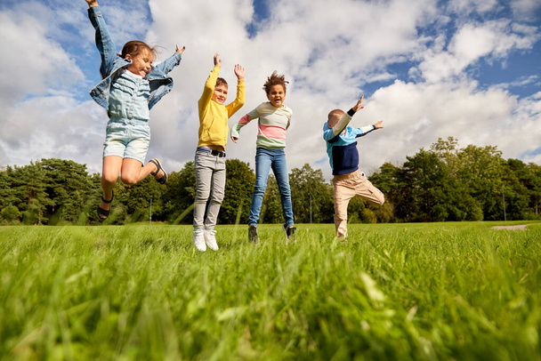 happy children jumping at park - Zdjęcie, obraz