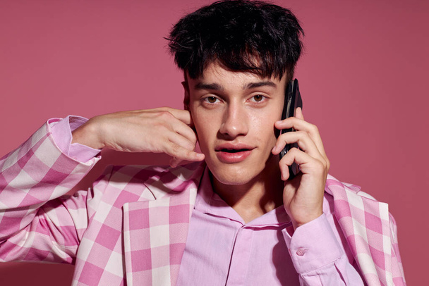handsome guy with a phone in hand pink blazer fashion elegant style Lifestyle unaltered - Valokuva, kuva