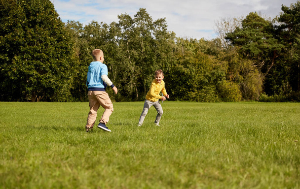 happy boys playing and running at park - Fotó, kép
