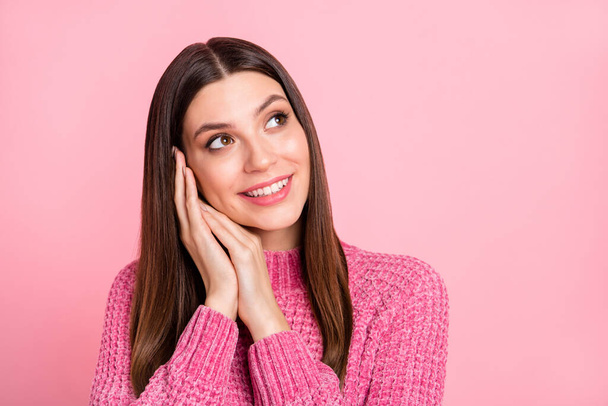 Portret van brunette optimistische meisje handen hoofd blik lege ruimte dragen roze trui geïsoleerd op karmozijn kleur achtergrond. - Foto, afbeelding