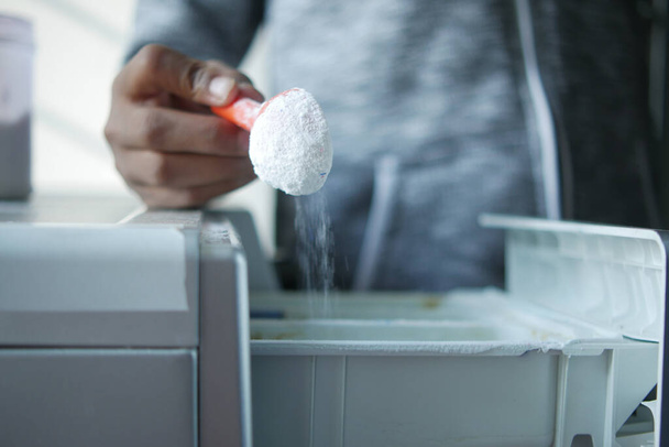 pouring Washing powder in plastic tray of washing machine  - Фото, изображение
