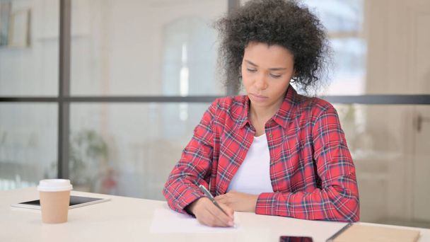 Afrikanerin schreibt im Amt auf Papier - Foto, Bild