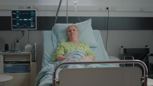 Porträt eines älteren Patienten, der im Krankenhausbett liegt - Filmmaterial, Video