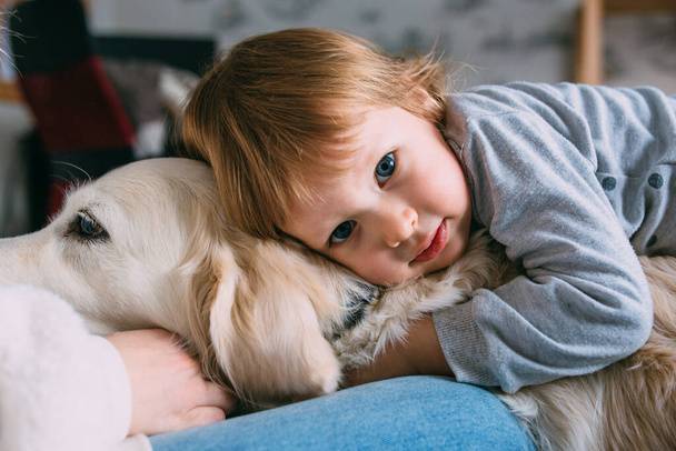 Cute baby and his labrador retriever at home on the bed. - Valokuva, kuva