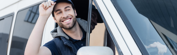 Positive courier holding cap while driving auto, banner  - Fotó, kép