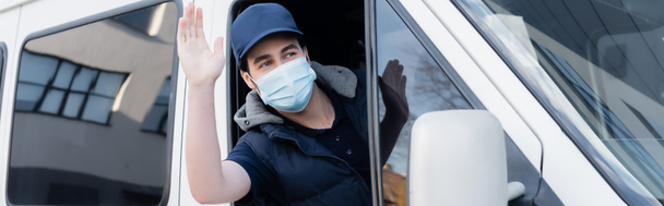 Delivery man in medical mask waving hand while driving auto, banner  - Photo, Image