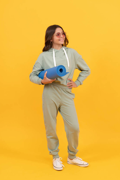 full length of happy child in sportswear and sunglasses with fitness mat. fit your body. - Fotografie, Obrázek