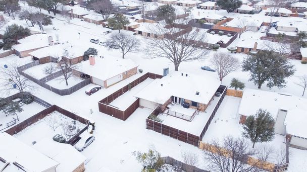 Dallas, Teksas, ABD yakınlarındaki mahalle caddesinde bulunan evleri ve arabaları hava manzaralı yoğun kar kapladı. Kar fırtınasından sonra büyük arka bahçeli banliyö evleri ayrıldı - Fotoğraf, Görsel