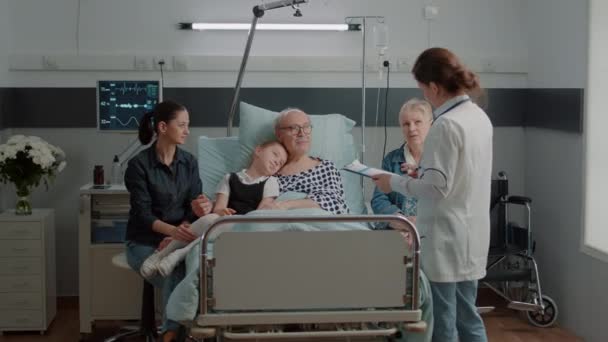 Gros plan du médecin consultant un patient malade avec sa famille en visite - Séquence, vidéo