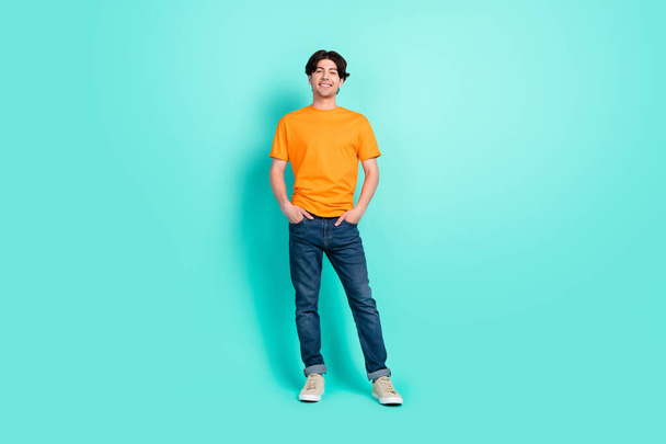 Full size photo of funny brown hair young guy stand wear t-shirt jeans sneakers isolated on blue background. - Φωτογραφία, εικόνα