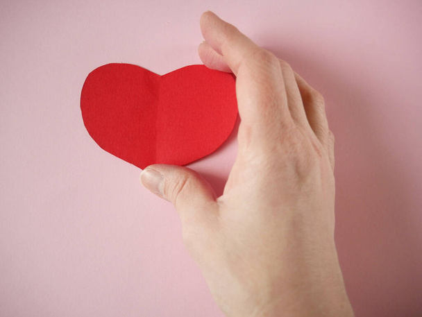 Kırmızı kalbi tutan el. Organ bağışı, aile sigorta konsepti. Dünya Kalp Günü, Dünya Sağlık Günü. Aşk ve Sevgililer Günü 'nün sevgili kavramı. Üst görünüm - Fotoğraf, Görsel