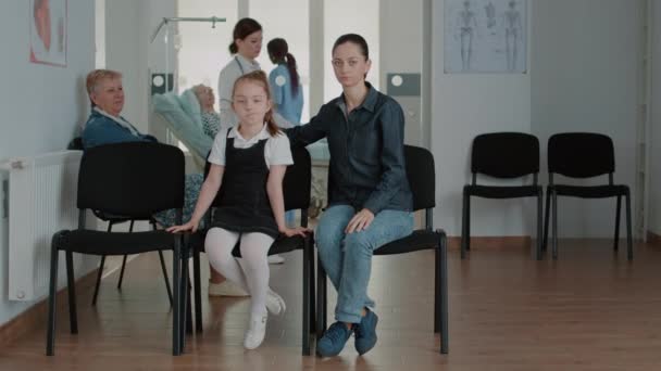 Portrait of mother and little girl in waiting room at clinic - Filmagem, Vídeo