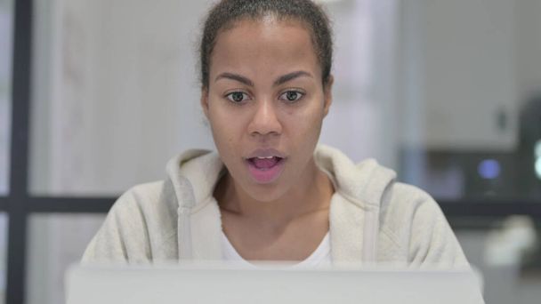 Primer plano de la mujer africana celebrando el éxito en el ordenador portátil - Foto, imagen