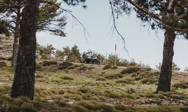 Sierra de los Filabres, Spain - May 5th 2021: Motorbike rider riding a BMW R 1250 GS motorcycle in a mountain road across beautiful turns, during Dunlop Xperience event in Sierra de los Filabres, Spain. - Photo, Image