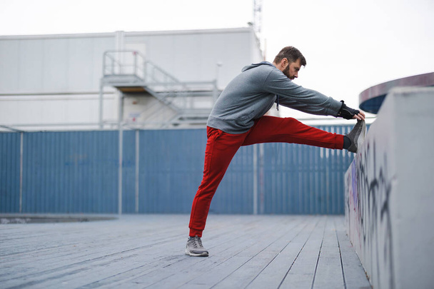 Young man exercising in urban setting - Foto, Imagen