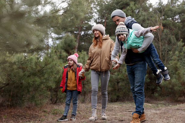 Happy family spending time together in forest - Fotoğraf, Görsel