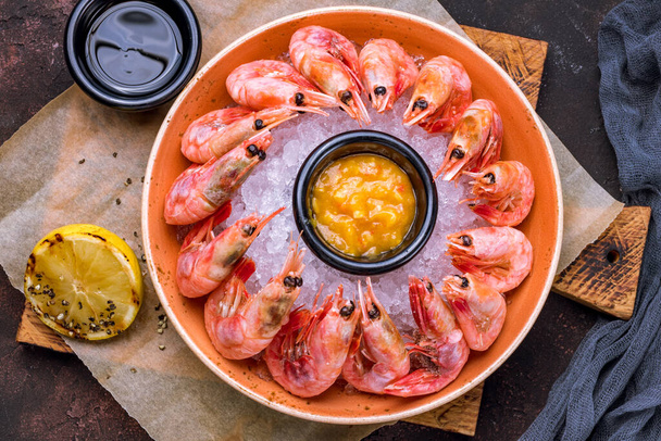 Fried langoustines on the Board with sauce and lemon top view - Foto, afbeelding