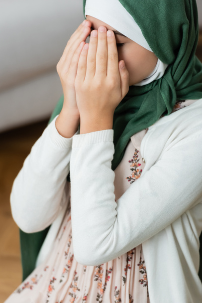 Teen kid covering face while praying at home  - Valokuva, kuva