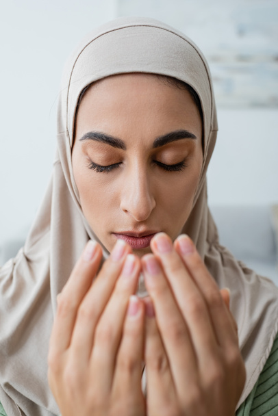 Portrait of young arabian woman praying with closed eyes  - Фото, зображення