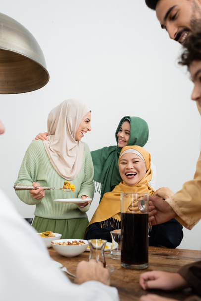 Vidám, többnemzetiségű muszlim család beszél az étel közelében otthon  - Fotó, kép