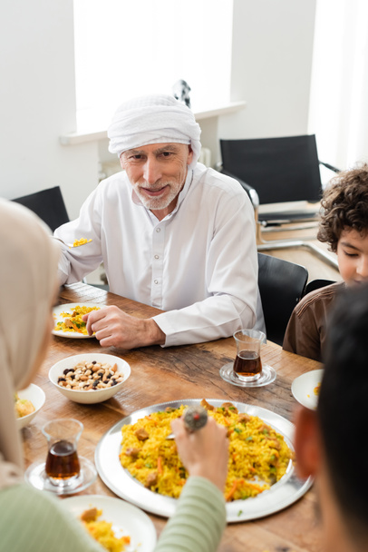 arabian boy having family dinner with muslim grandfather and blurred parents - Photo, Image
