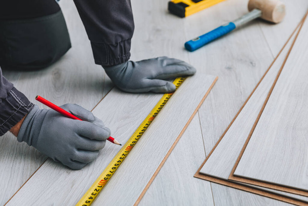 Handyman instalando piso de madera laminado nuevo - Foto, imagen