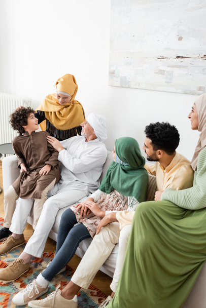 зрілий чоловік розмовляє з арабським онуком біля дружини та мультикультурної мусульманської сім'ї
 - Фото, зображення
