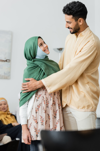 szczęśliwy arabski człowiek przytula muzułmańską córkę w hidżabie w domu - Zdjęcie, obraz