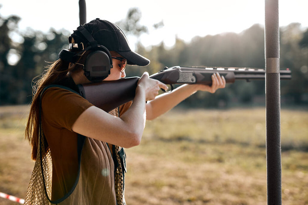 Young woman on tactical gun training classes. Lady with weapon, rear view - Фото, зображення